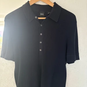 Marinblå ribbad pikétröja från Hugo Boss - Säljer pga den inte passar mig längre. Köpt för 600kr