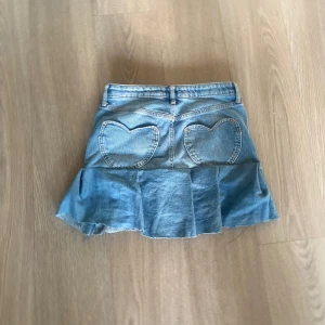 Jeans kjol.  - En blå jeans kjol med hjärt formade fickor där bak. Jätte fin, och är ganska så kort. 