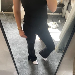 Svarta bootcut byxor från BikBok - Svarta bootcut kostymbyxor från BikBok i storlek 34. Byxorna har låg midja och är utsvängda där nere. Säljer dom på grund av att dom är försmå. 