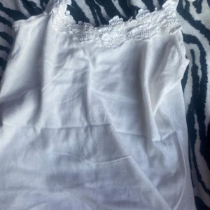 Vitt linne 💕 - Super gulligt vitt linne med blomm och spets detaljer ! Perfekt till sommarn ❣️ 