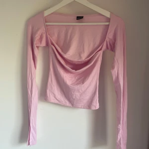Ljusrosa långärmad topp Gina Tricot - Supersöt ljusrosa långärmad topp från Gina Tricot. Toppen är figurnära och har en enkel, stilren look som passar perfekt till jeans eller kjol. Mjuk och stretchig bomullskvalitet för en bekväm känsla.