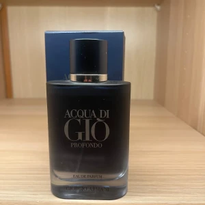 Acqua di Giò Profondo Eau de Parfum - Acqua di Giò Profondo från Giorgio Armani är en elegant herrparfym i en stilren, mörkblå glasflaska med silverdetaljer. Doften är fräsch och djup, perfekt för dig som gillar marina och maskulina toner. Flaskan har en modern, matt finish och kommer med originalkartong.