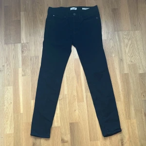 Svarta skinny jeans från SELECTED HOMME W31 L32 - Svarta skinny jeans från SELECTED HOMME med klassisk femficksdesign och smal passform. Byxorna har normal midja och är tillverkade i stretchigt bomullsmaterial för en bekväm känsla. Perfekta för en clean och stilren look.