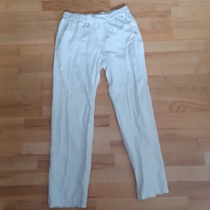 Vita linnebyxor med dragsko - Snygga och luftiga vita linnebyxor med elastisk midja och dragsko. Perfekta för varma dagar och chill vibes. Raka ben och enkel design som passar till det mesta. Byxorna har fickor i sidorna och är riktigt sköna att bära.