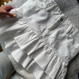 Vit volangkjol från Gina Tricot - Supersöt vit kortkjol från Gina Tricot med volanger, superfin aldrig använd så den blev lite lång på mig, storlek 170 men passar s/m