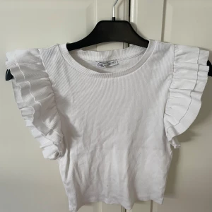 Vit volangtopp från Zara - Supersöt vit topp från Zara med ribbad struktur och volang armar🤍