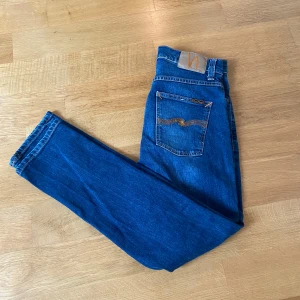 Blå nudie jeans, 30/30 - Ett par snygga blå jeans från Nudie Jeans i färgen blå med lite washed design. Storleken är 30/30 i modellen grim tim. Inga synliga defekter och hör av dig vid eventuella frågor!