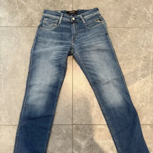 Blå Replay jeans straight fit - Snygga blå jeans från Replay med klassisk femficksdesign och raka ben. Jeansen har en mellanblå tvätt med lätt slitning och normal passform. Perfekta för en avslappnad och stilren look. Dm för frågor!