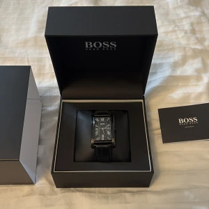 Hugo boss klocka - Svart Hugo Boss Tank klocka. Helt oanvänd✅. Reglerbar storlek. Låda och tillbehör medföljer. Köpt för ca 1800 kr. Säljer för 999 kr. Pris kan diskuteras litegrann såklart.