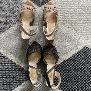 Glittriga sandaler med klack - Två par sandaler från Karimi Sadaf med glittriga detaljer, öppen tå och bred klack. Ett par är i champagnefärgat och ett par i svart, båda med justerbar rem runt vristen och dekorativa utskärningar framtill. Perfekta för dig som gillar att sticka ut. Dom ljusa har storlek 38 och dom svarta Storlek 38