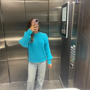 Turkos stickad tröja med ribbad struktur - Säljer en turkos stickad tröja med ribbad struktur och rund hals. Tröjan har långa ärmar och en relaxed passform som är både snygg och bekväm. Perfekt att styla med jeans eller kjol för en fräsch look.