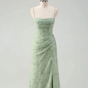 Ljusgrön långklänning med blommönster - Superfin ljusgrön långklänning med smala axelband och subtilt blommönster. Klänningen har en figurnära passform med draperad midja och slits framtill. Perfekt för dig som vill ha en romantisk och elegant look. Kan användas som balklänning och den är ny helt oanvänd men prislapp. Storlek US 2 som motsvarar en 32. 