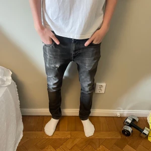 Ett par jeans från nudie jeans  - Säljer ett par svarta jeans från Nudie Jeans med slitningar modellen heter grim trim skriv vid fler funderingar !
