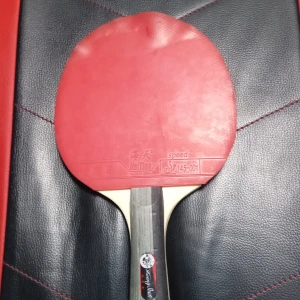 Pingisrack Huang Shan - Bilderna visar ett pingisracket av märket Huang Shan med Haitan-gummi på båda sidor (röd och svart). Racketen är märkt med ITTF-godkännande och är designad för fart. Perfekt för dig som vill ta ditt bordtennisspel till nästa nivå!  Den har bra stust och bra skruvar men den har JÄTTE BRA FART. Perfekt för dig som är bra i pingis. Om du är nybörjare så kan du köpa den andra pingisracket som jag la upp perfekt för nybörjare! 