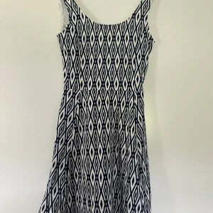 Mönstrad ärmlös kortklänning - Supersnygg ärmlös klänning med grafiskt mönster och rundad hals. Perfekt för dig som gillar en stilren men ändå iögonfallande look.