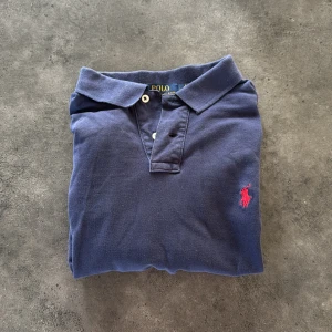 Pike från Ralph Lauren - Klassisk marinblå pikétröja från Ralph Lauren. Tröjan är i fantastiskt skick och M i storlek (passar mig perfekt som 187). Pris kan diskuteras vid snabb affär! Byten är alltid intressanta!!!