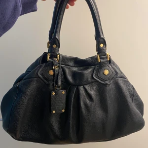 Svart skinnväska Marc by Marc Jacobs - Säljer min favoritväska från Marc Jacobs! Är äkta och i superfint skick 🌟 Den har inga slitningar eller skavanker därav det höga priset ❤️