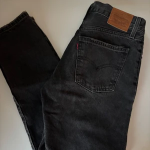 Svarta Levi's straight jeans - Säljer ett par svarta Levi's jeans i modellen Middy Straight. Klassisk femficksdesign, raka ben och medelhög midja. Jeansen är i kraftig denim och har en snygg mörk tvätt. 💕