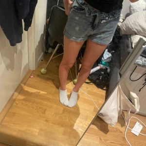 Blå jeansshorts XS - Snygga blå jeansshorts i storlek XS. De har en klassisk femficksmodell, slitna detaljer och uppvikta benslut. Perfekta för sommaren och ger en avslappnad vibe till din outfit. Tyvärr är de för små för mig men verkligen superfina nu inför sommaren!