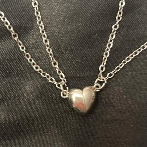 Bästa vänner hjärta halsband för par magnetiskt hjärta  - Två halsband med varsin magnetiskt hjärthalva. Halvorna klickar ihop med magnet när de förs tillsammans. Trädd på kedja i silverimitation som är justerbar 45-50 cm. Berlockerna är ca 1 x 0,5 cm.   Perfekt att dela med din partner, bästa vän eller någon anan som betyder mycket!❤️ 