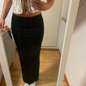 Svart långkjol i tight modell - Svart lågmidjad långkjol från gina med scrunch på sidorna xs-s