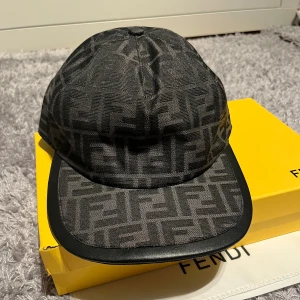 Fendi keps - 1•1,En helt ny och oanvänd Fendi keps som är helsvart med justerbar storlek men egentligen så är den riktiga storleken M/57cm. Fråga ifall du har en fundering 