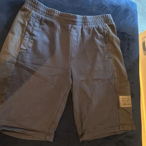 Svarta shorts EA7 Emporio Armani - Mörkblå shorts från EA7 Emporio Armani med elastisk midja och sidofickor. Snygg logga på vänster ben och stilren design. Perfekta för chill dagar eller sport. Mjukt material som känns skönt mot huden.