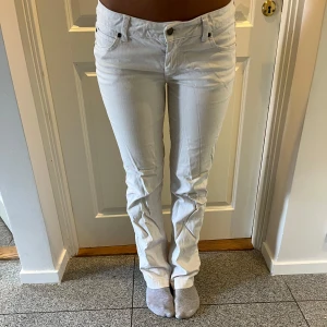 Vita straight jeans med låg midja - Så snygga vita straight låga jeans! Jag har lagt in ett resorband i midjan som man kan ta bort men det gör att den passar många storlekar.💕 midjemåttet (utan resor) är ca 42 cm. Innerbenslängden är ca 83cm💕 tyvärr har dom en slitning i grenen och i innerlåret men ingen man tänker på.