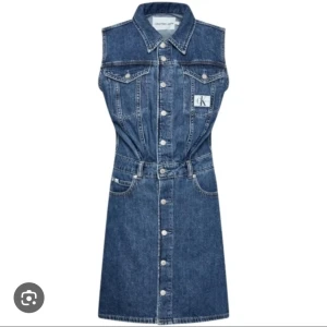 Ärmlös jeansklänning från Calvin Klein Jeans - Säljer en cool ärmlös jeansklänning från Calvin Klein Jeans med klassisk skjortkrage, knappar framtill och fickor på bröstet. Klänningen har CK-logga både fram och bak och är i en mörkblå denim. Perfekt för dig som gillar en avslappnad men trendig stil. Helt ny/aldrig använd! Passar en M/36-38.