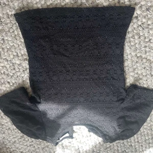 Svart spetsblus med puffärm från Vila - Säljer en svart blus från Vila med vackert spetsmönster och puffiga korta ärmar. Perfekt för dig som gillar romantiska detaljer och vill ha något extra till outfiten. Blusen har rund halsringning och är figurnära.