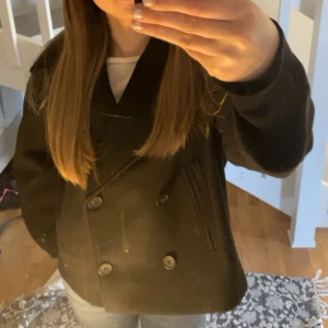 Svart kappa  - Säljer en svart jättefin kappa med klassisk dubbelknäppning och krage. Jackan har långa ärmar och två fickor framtill. Perfekt för dig som vill ha en stilren och tidlös look. 💗💗