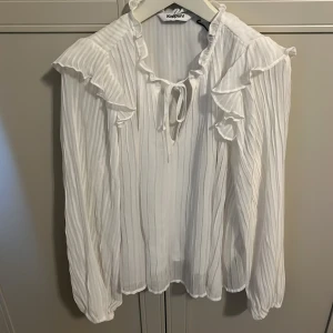 Vit blus från Kappahl  - Säljer denna söta elgeganta blusen från Kappahl. Blusen har söta volanger vid ärmarna samt en v ringning. Passar till alla tillfällen. 