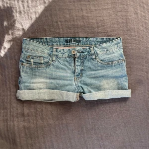 Ljusblå lågmidjade jeansshorts  - Jättesnygga ljusblå och lågmidjade jeansshorts från Vero Moda. De passar perfekt och är i storlek M. Perfekta för varma dagar och enkel att matcha med olika toppar! 