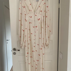 Adoore positano dress - Säljes Adoore Positano dress vit med röda blommor i storlek 36. Enbart använd en gång, men tyvärr för liten för mig så jag behöver byta till strl 38.  Byte till en strl 38 är intressant!  Annars säljes den för 1400kr, nypris är 1695kr.