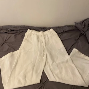 Vita linnebyxor  - Säljer ett par vita linnebyxor från H&M i storlek XS. Byxorna har resår och dragsko i midjan samt sidofickor. Perfekta för varma dagar tack vare det svala linnematerialet och den lösa passformen.