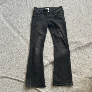 Svarta bootcut jeans med knappar. - Säljer ett par svarta lågmidjade bootcut jeans med tre knappar i midjan ifrån Gina tricot. Pris kan diskuteras privat. Stretchigt material och har bara använt 3 gånger ungefär så de är precis som nya. 