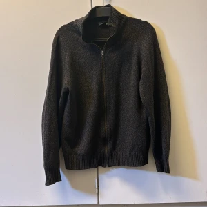 Mörkbrun stickad kofta från Burberry - Säljer en mörkbrun stickad kofta från Burberry London med dragkedja framtill och diskret broderad logga på bröstet. Koftan har hög krage och långa ärmar, perfekt för kyligare dagar. Klassisk och stilren design. Tröjan har använts några gånger. Nypris 2500, mitt pris 559! Priset går att diskuteras! Hör av er vid minsta lilla fundering🤗