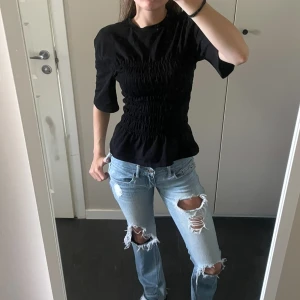 Svart smockad topp - Säljer en svart topp med smockad topp från Other Stories. Endast använd några gånger