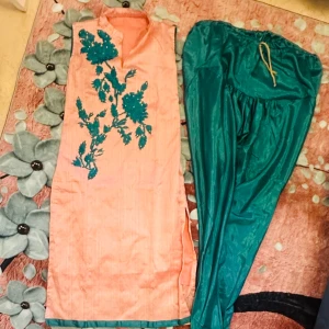 Indisk traditionell outfit – storlek S – som ny - Vacker och unik traditionell indisk klädsel i storlek S. Består av en ljus korallfärgad tunika med broderi och glansiga gröna byxor. Perfekt till fest och speciella tillfällen. Endast använd en gång – i nyskick.