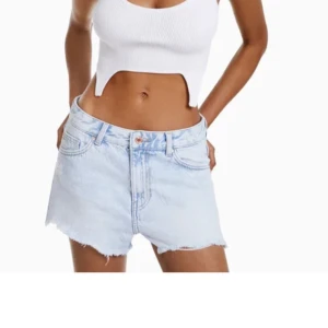 Ljusblå jeansshorts från Bershka - Säljer ett par ljusblå lågmidjade jeansshorts från Bershka med fransar och slitna detaljer framtill. Perfekta för varma dagar och enkel att matcha med allt.