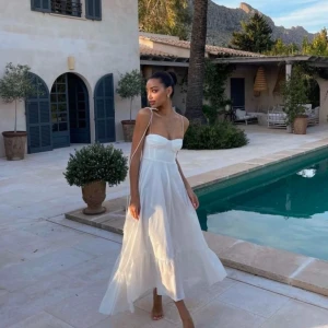 Vit långklänning med volang och smala axelband - Säljer denna virala populära vita klänningen från Zara. Vit, ärmlös sommarklänning med smala axelband. Klänningen har en figurnära överdel och en utsvängd kjol Perfekt för varma dagar och kvällar.  Från Zara Strl L  Helt ny med prislapp på. Köpt 2024, slutsåld i Sverige.