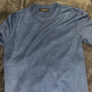 Blå stickad tröja från Primark - Säljer en snygg blå stickad tröja från Primark i storlek XS. Tröjan har rund halsringning och långa ärmar, perfekt för kommande sommar kvällar.