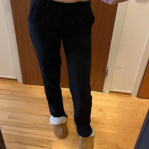 Svarta kostymbyxor med normal passform - Snygga svarta kostymbyxor med klassisk rak passform och normal midja. Perfekta till en stilren look och passar till många olika outfits. Byxorna har enkel design utan synliga detaljer och är gjorda i ett mjukt material.