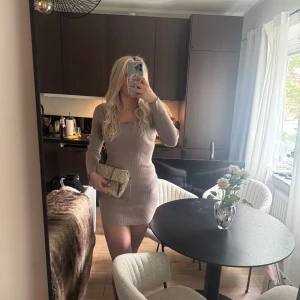 Beige ribbad kortklänning - Säljer en beige ribbad kortklänning med lång ärm och fyrkantig ringning. Klänningen har en tight passform och är superskön!🥰🫶🏼