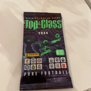 Top Class 2025 Pure Football - Upptäck de hetaste fotbollsstjärnorna med Paninis officiella Top Class 2025 trading cards! Perfekt för dig som älskar fotboll och vill samla på unika kort från världens största klubbar och landslag. 8 kort i varje paket – spänning och samlarvärde i ett!