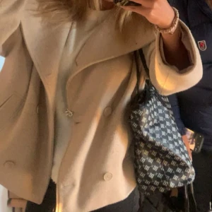 Beige kappa - Säljer en snygg beige kappa perfekt för vintern och hösten, kappan har knappar så man kan stänga och passar perfekt till allt. 