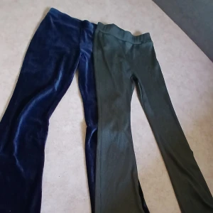 Två par ribbade manchesterbyxor - Säljer två par ribbade manchesterbyxor med bootcut. Ett par är mörkblå från Rock Today och det andra är mörkgröna. Båda har hög midja och stretchig resår i midjan för extra komfort. Perfekta för dig som gillar retrovibbar och vill ha något mjukt och snyggt.