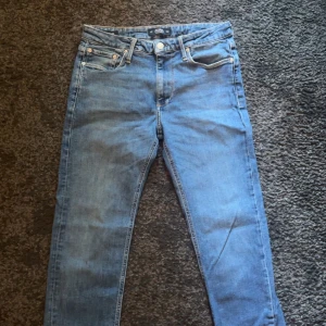 Ljusblå skinny jeans 29/30 - Säljer ett par ljusblå skinny jeans med klassisk femficksdesign och dragkedjegylf. Jeansen har en smal passform och är tillverkade i mjukt denimtyg som sitter snyggt på benen. Perfekta för dig som gillar en clean och enkel look.
