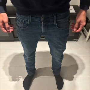 Blå Replay jeans, modell Anbass  - Tjenare! Säljer ett par snygga blå slimfit jeans från Replay, modell anbass. Dem har användits mycket och därför säljer jag dem för ett lågt pris. De har en liten defekt under dragkedjan men är inte ett hål utan bara en liten väldigt sliten del. Tveka inte på att höra av dig om du har funderingar eller vill ha mer bilder😊! Priset går såklart att diskutera 