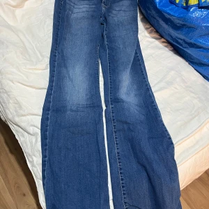 Blå bootcut jeans från Vero Moda - Snygga blå jeans från Vero Moda med bootcut passform och klassisk femficksdesign. Jeansen har medelhög midja och är tillverkade i mjuk denim med lätt tvättad look. Perfekta för dig som gillar en avslappnad men trendig stil.